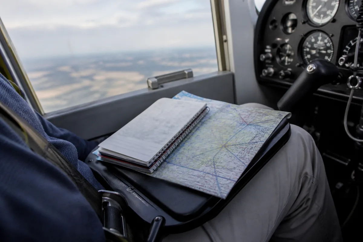 Vue d ensemble d un carnet de navigation et d une carte aeronautique en cockpit